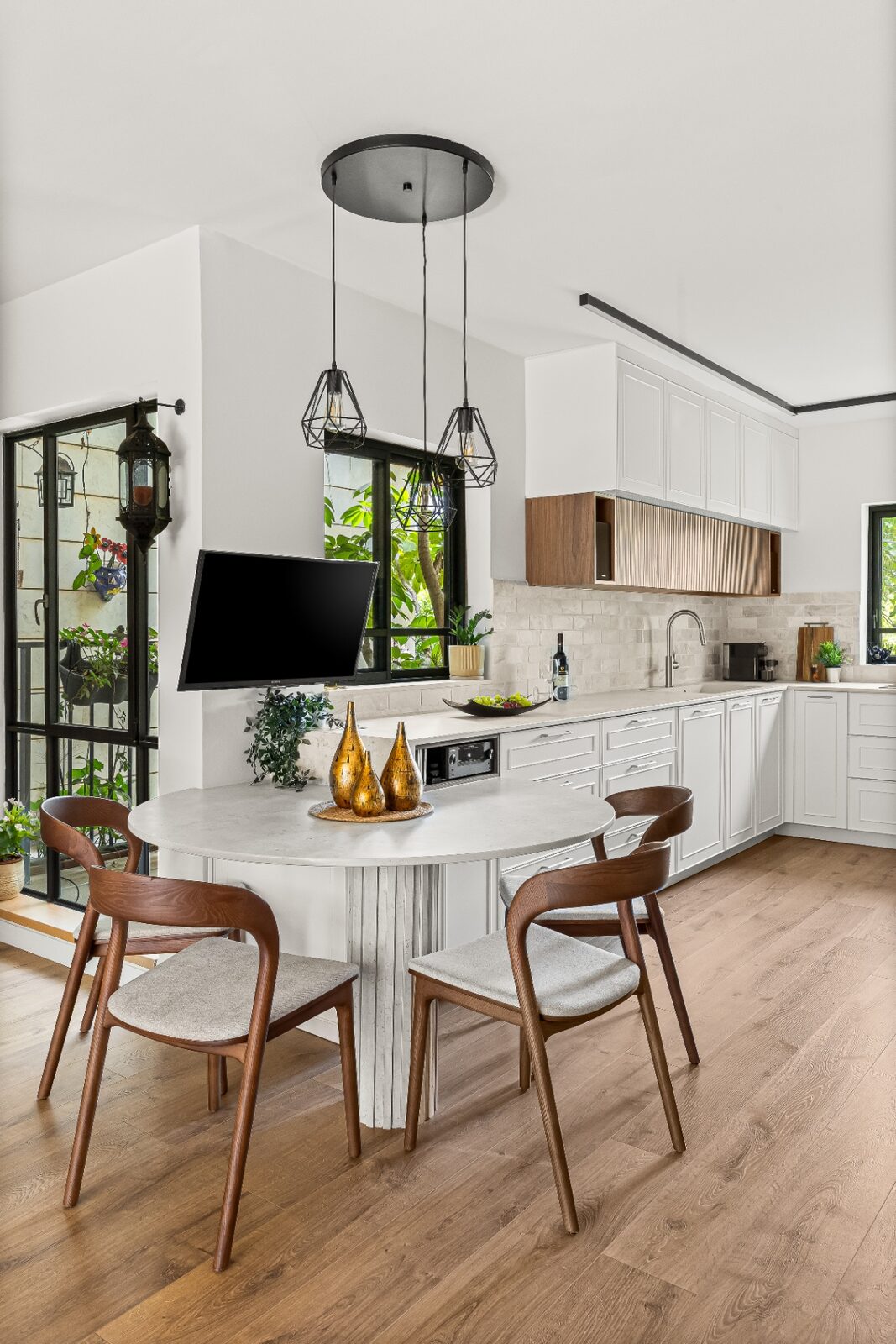Rishon LeZion kitchen with round dining table and fluted wood cabinetry