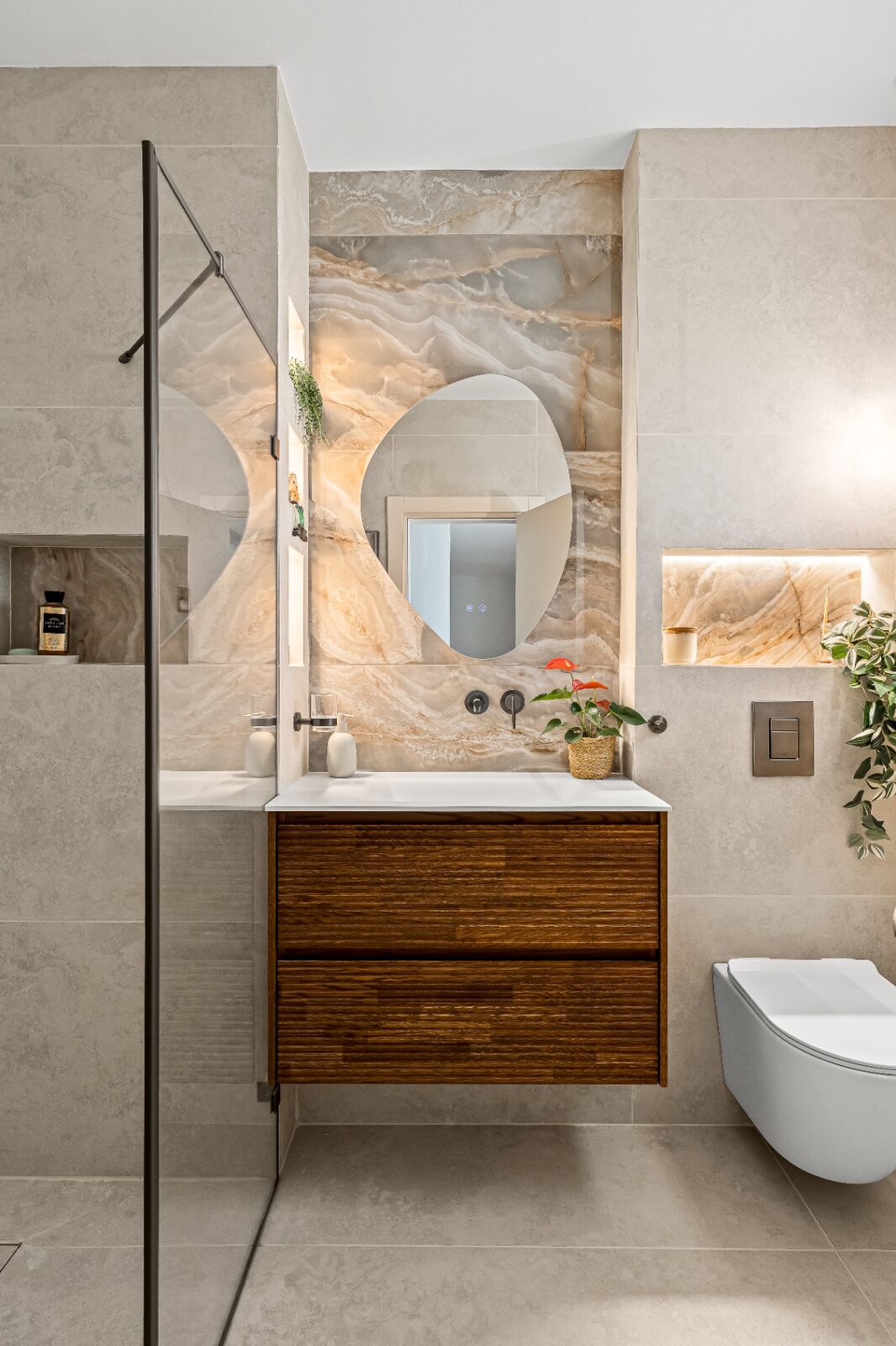 Rishon LeZion guest bathroom with onyx feature wall and fluted wood vanity