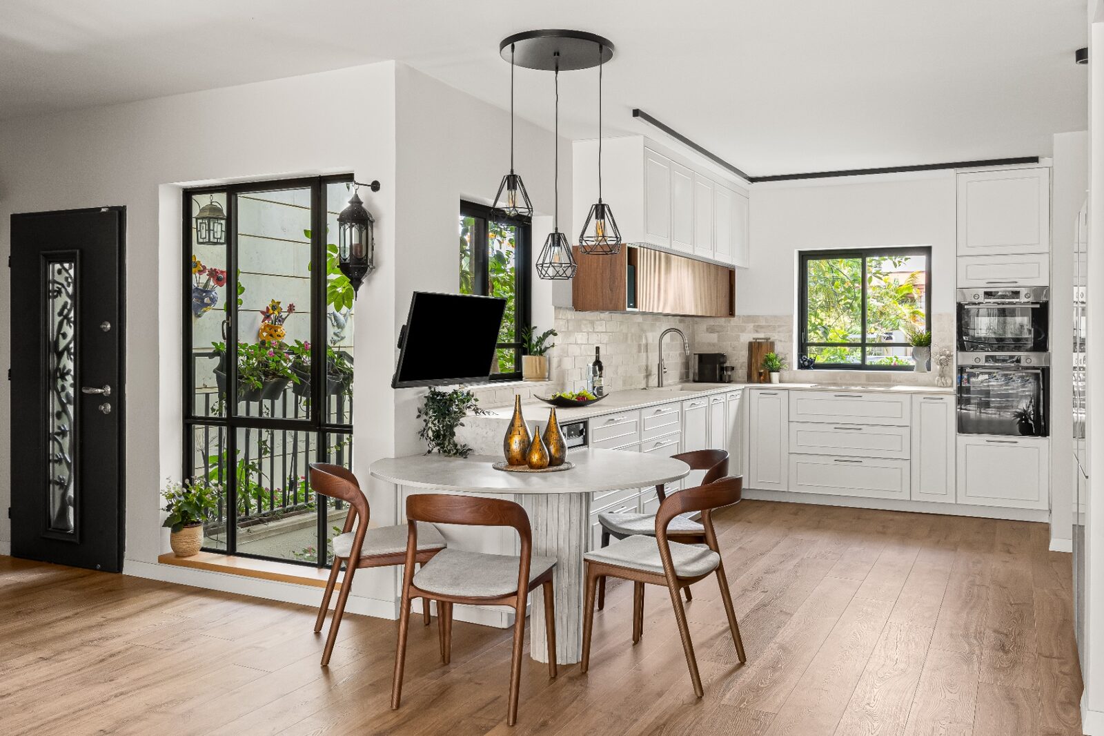 Rishon LeZion kitchen overview with dining table and garden-facing windows