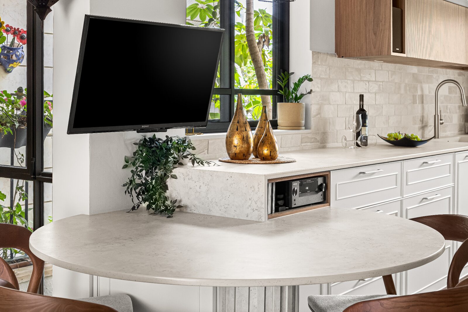 Rishon LeZion kitchen island detail with floating TV panel, stone counter and decorative styling