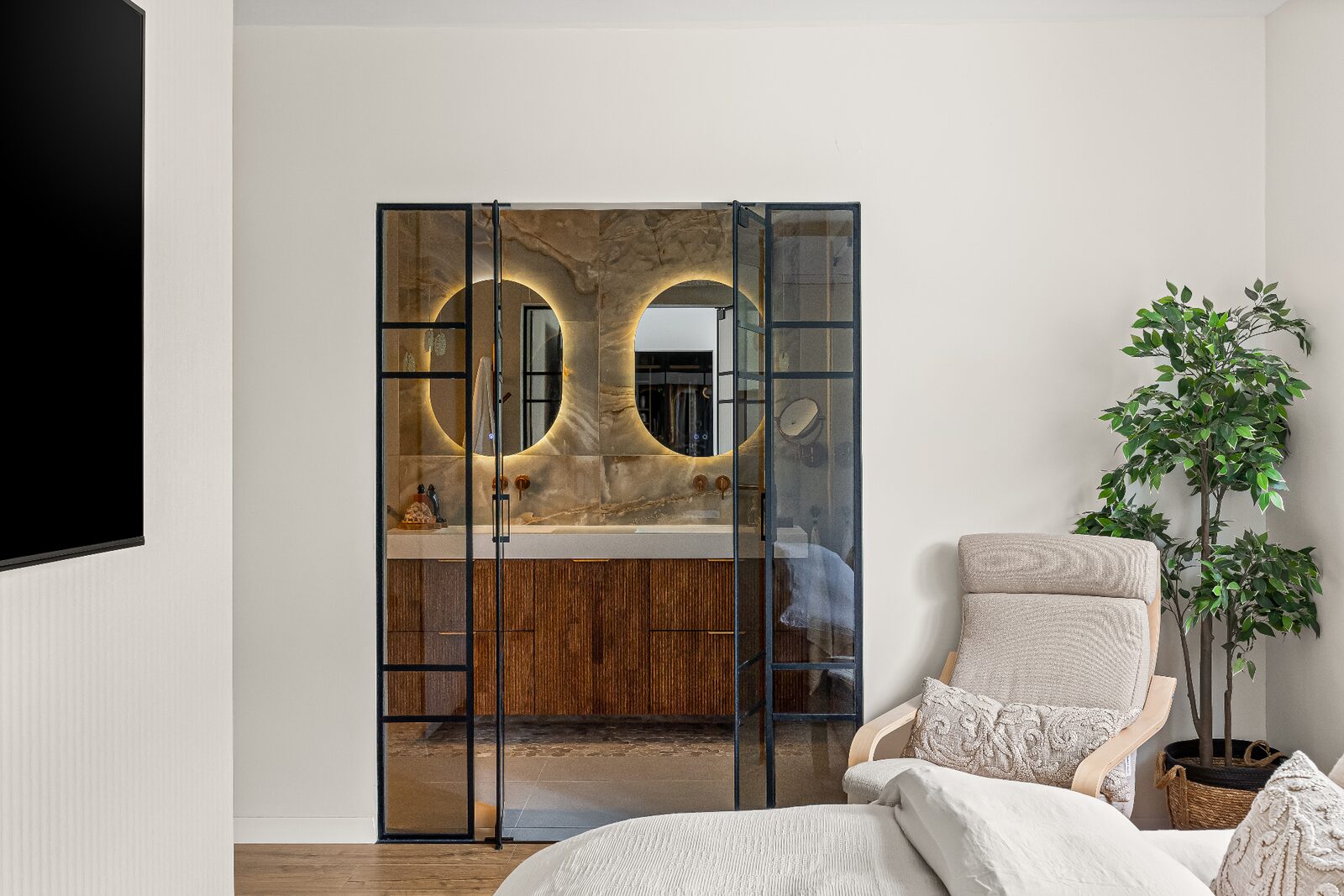 Rishon LeZion bedroom with glazed steel doors opening to the master bathroom vanity
