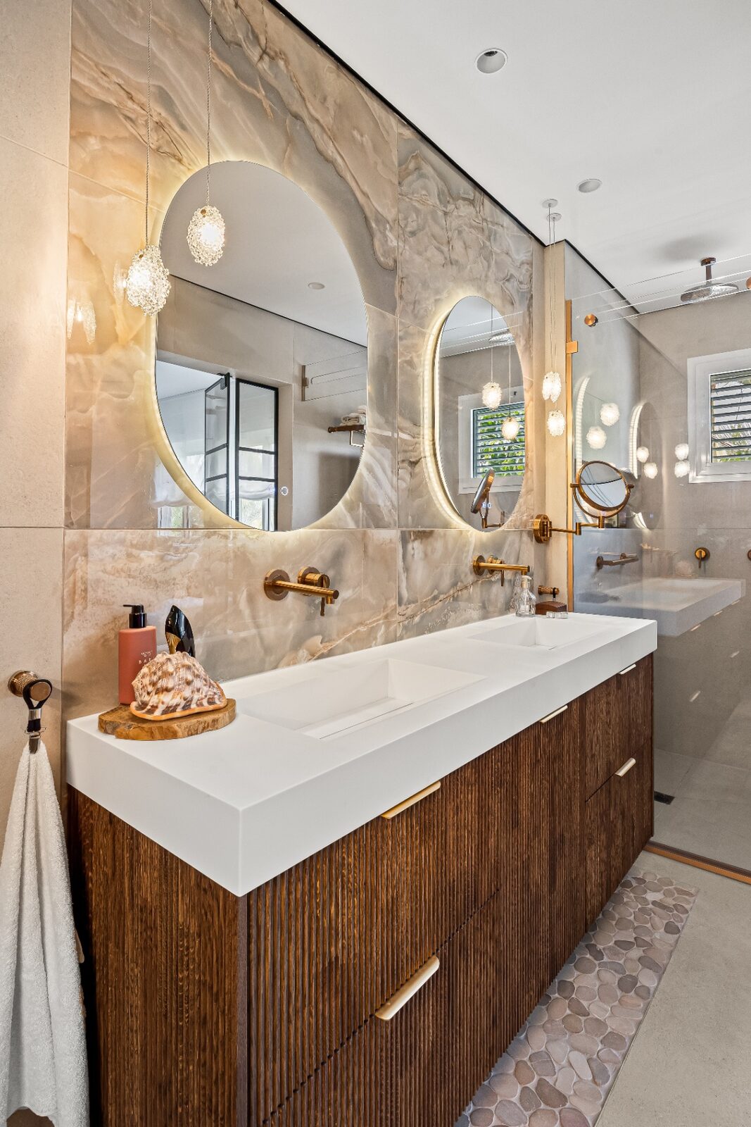 Rishon LeZion master bathroom angle with twin oval mirrors and pebble stone floor