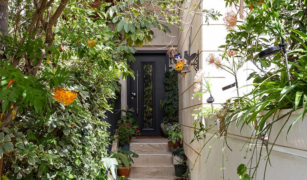 Rishon LeZion private house garden entrance pathway with lush planting and black front door