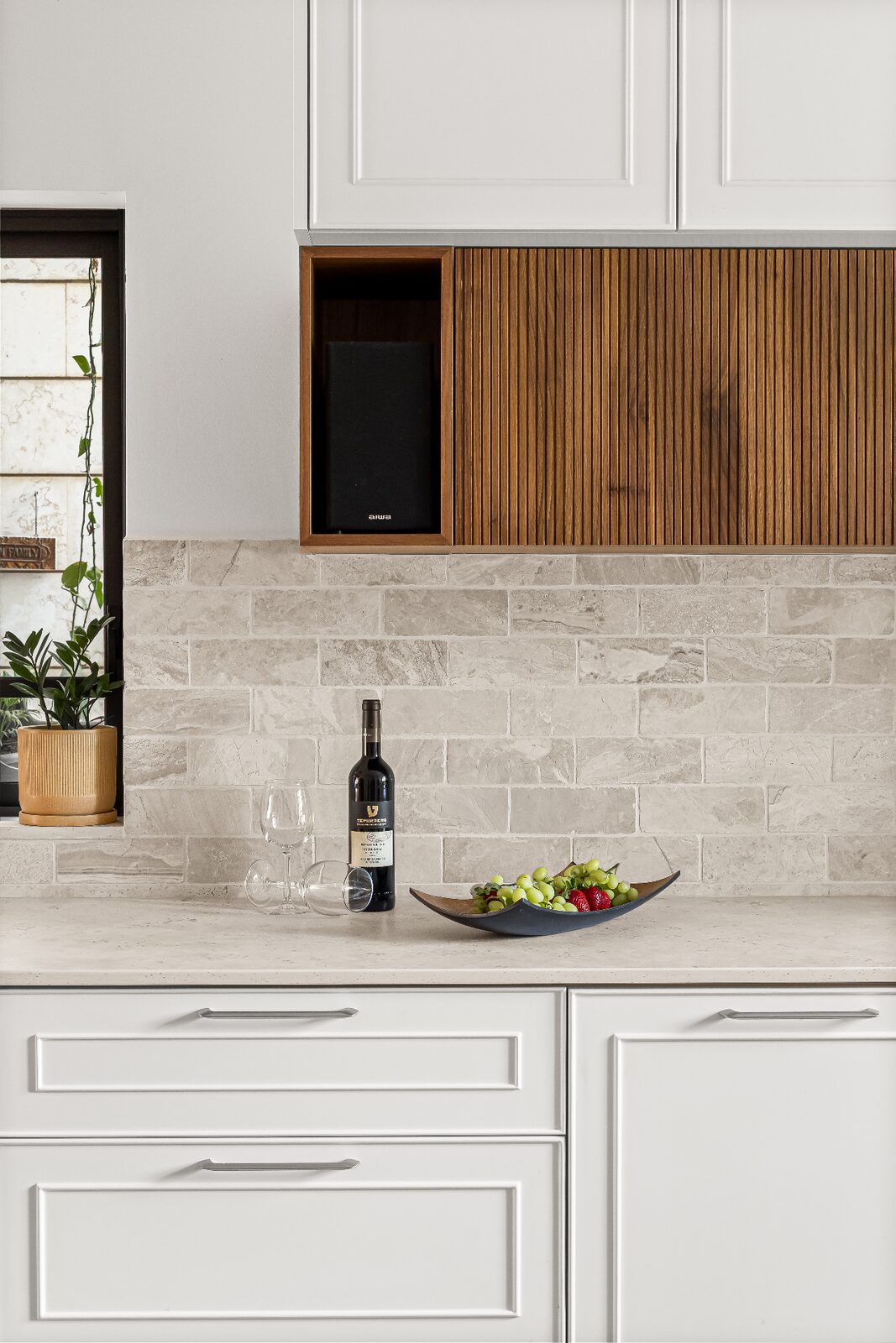 Rishon LeZion kitchen styling detail with fluted wood cabinet and stone backsplash