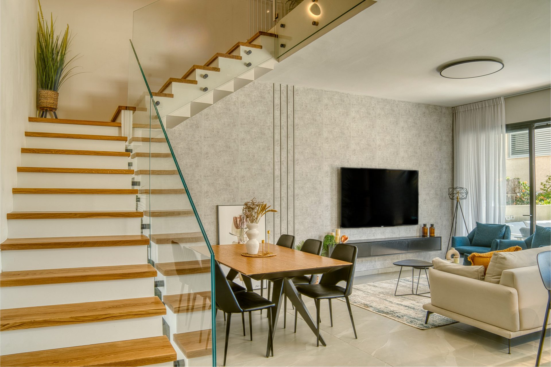 Gedera open-plan living room with dramatic floating staircase