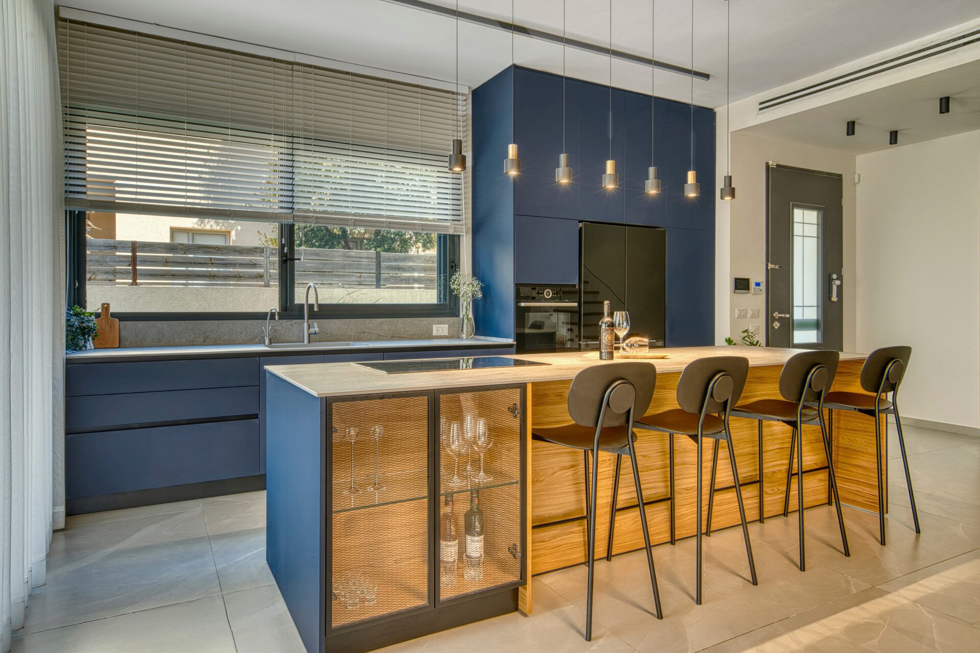 Gedera navy-blue kitchen with wood island and bar stools