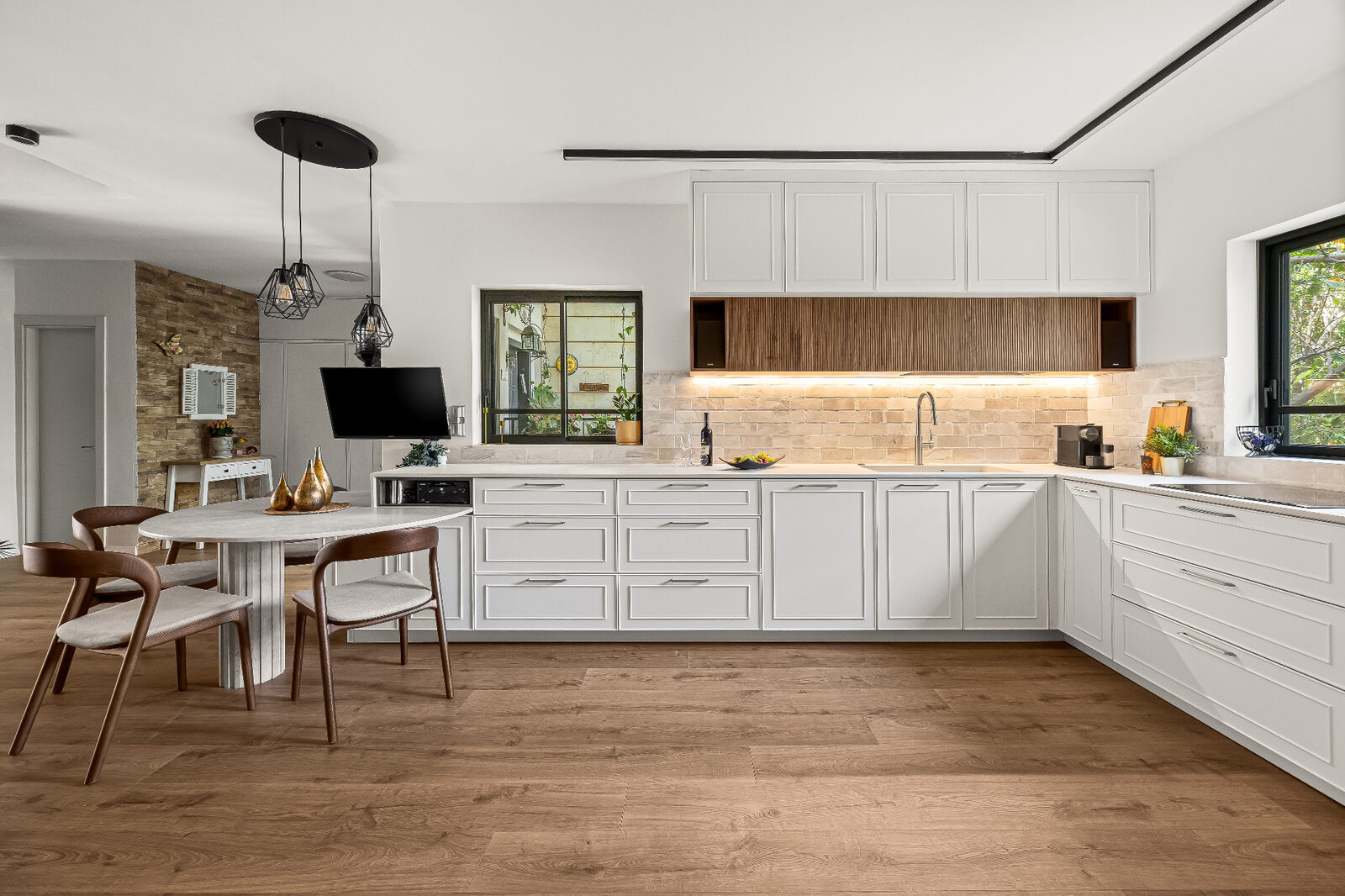 Rishon LeZion open-plan white kitchen with dining nook