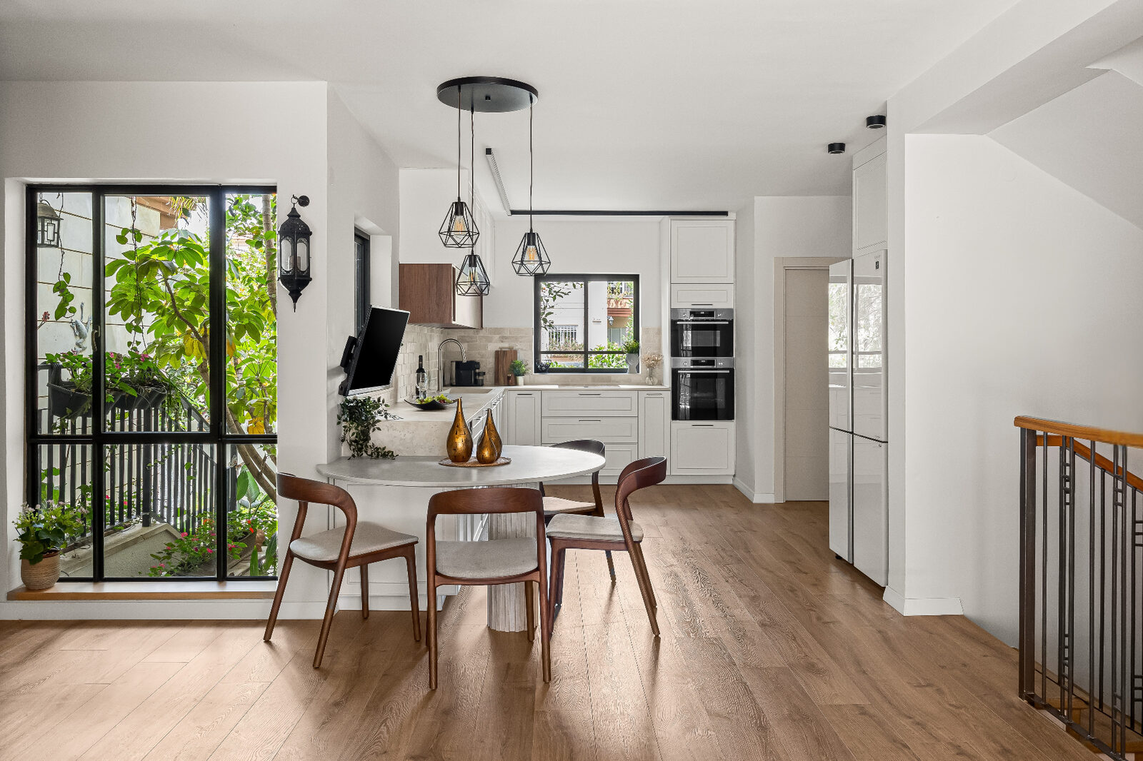 Rishon LeZion dining area beside garden window with pendant lights